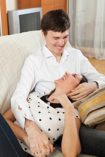 Laughing young couple on sofa — Stock Photo, Image