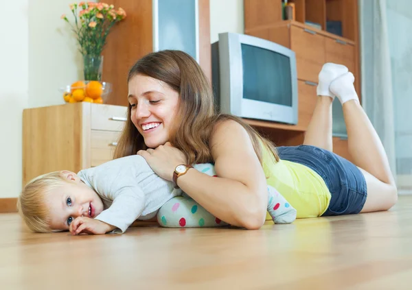 Happy mom with child on wooden floor — Stock Photo, Image