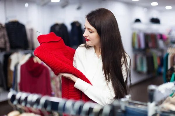 Ordinary girl choosing  sweater — Stock Photo, Image