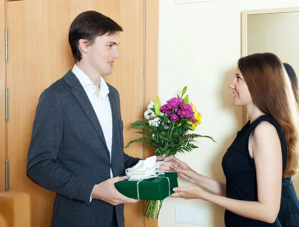 Uomo felice con fiori e confezione regalo — Foto Stock