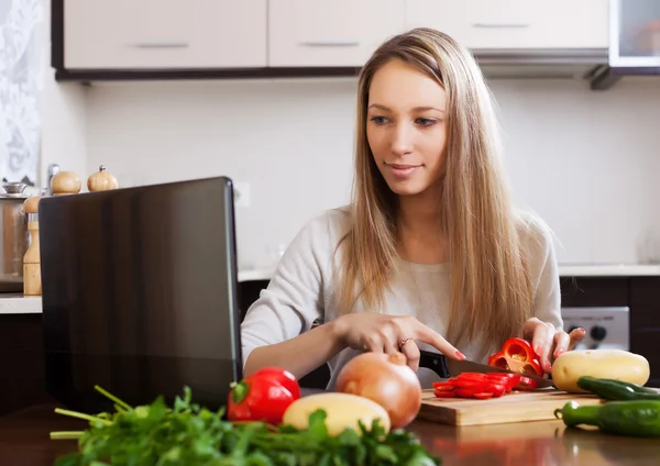 Femme cuisine avec ordinateur portable — Photo