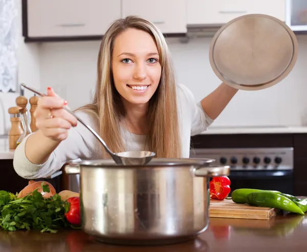 Улыбающаяся девушка с ковш варить суп — стоковое фото