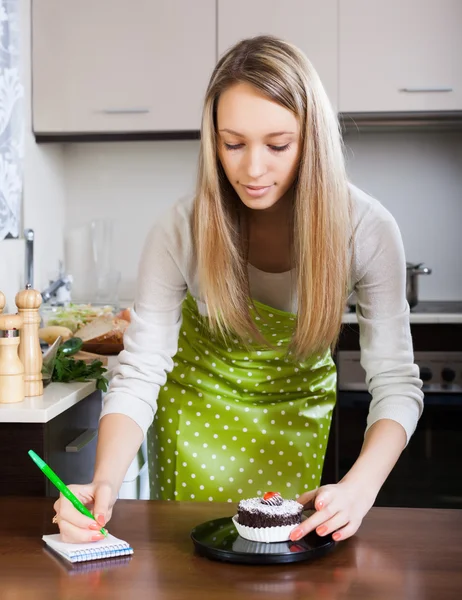 Blond tjej väger kakor — Stockfoto