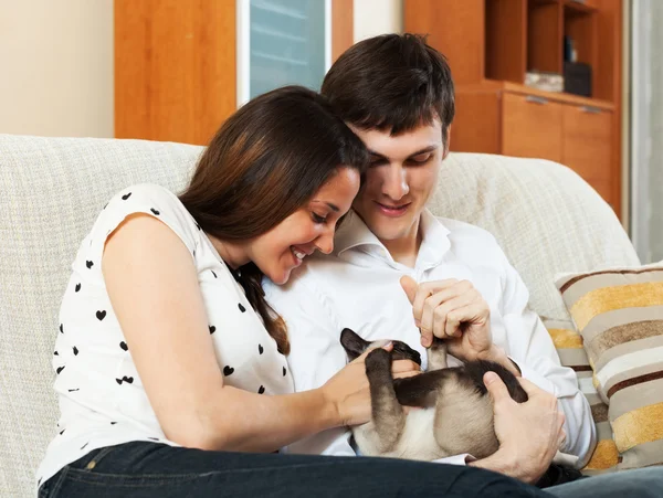 Jovem casal com gatinho em casa interior — Fotografia de Stock