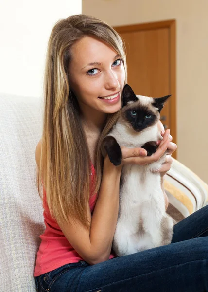 Girl with a Siamese cat  in the room Stock Photo