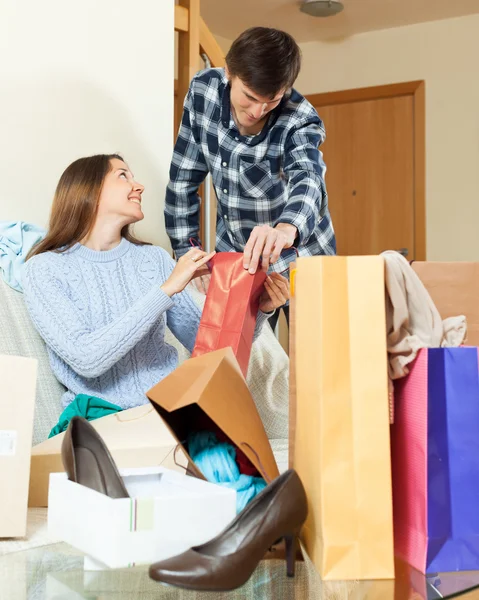 Pareja de amigos con ropa y bolsas — Foto de Stock