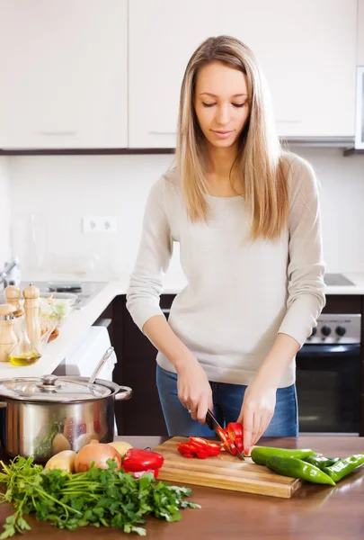 Mujer rubia casual rebanando pimiento rojo — Foto de Stock