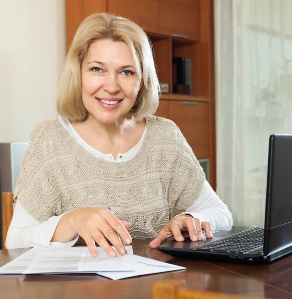 Mujer madura sonriente con portátil — Foto de Stock