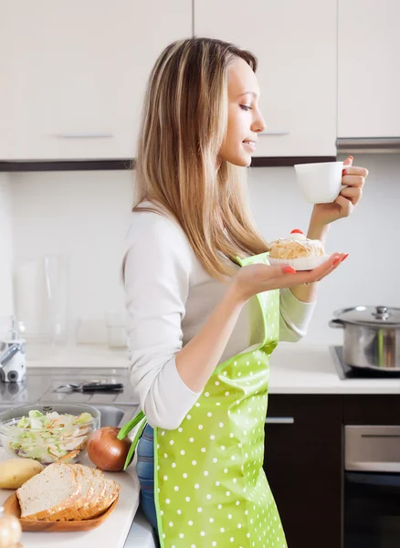 Vrouw met cakes en thee in keuken — Stockfoto