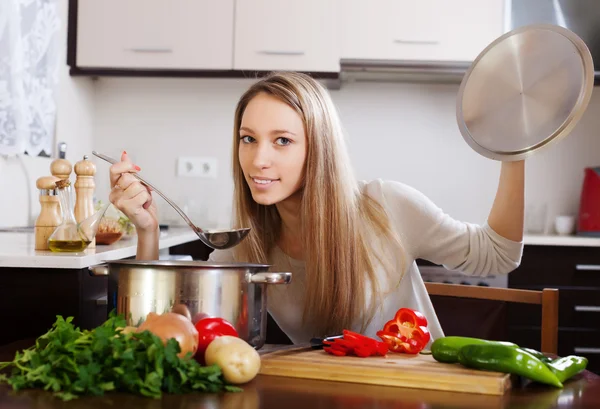 Женщина с ковш варить суп — стоковое фото