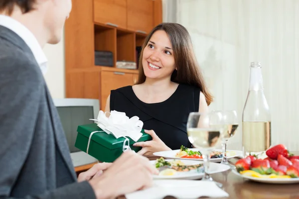 Girl giving gift during romantic dinner — Stock Photo, Image