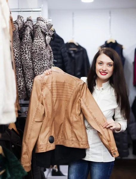 Девушка выбирает куртку в магазине одежды — стоковое фото