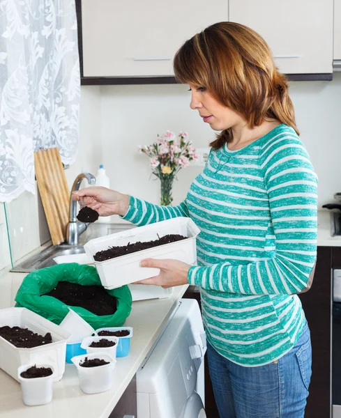 Ordinary woman  making soil for seedlings — Stock Photo, Image