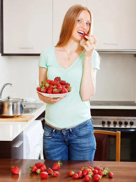 Pitkäkarvainen nainen syö mansikoita — kuvapankkivalokuva