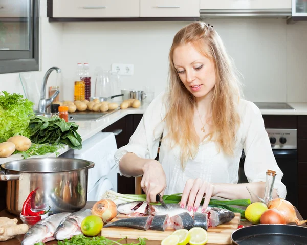 Blonde woman slicing raw  fish — Stock Photo, Image