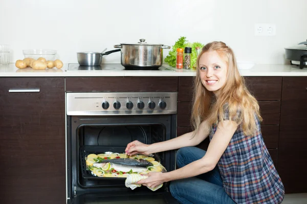 Huisvrouw koken zeevis en aardappelen — Stockfoto