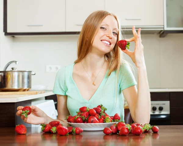 Long-haired girl eating strawberry — Stock Photo, Image