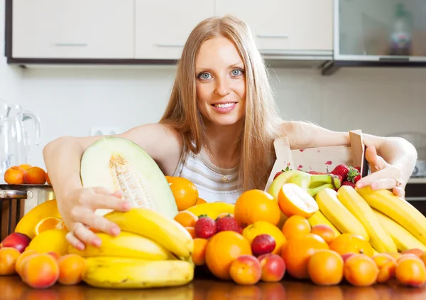 Ama de casa con frutas frescas en la cocina — Foto de Stock