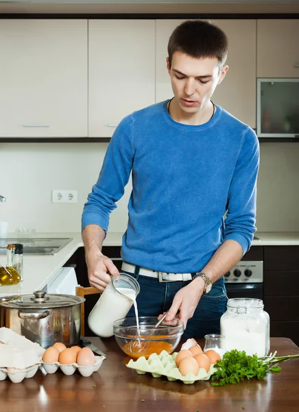 Guy pouring milk in bowl — Stock Photo, Image