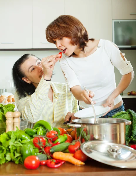 Couple flirtant cuisiner avec des légumes — Photo