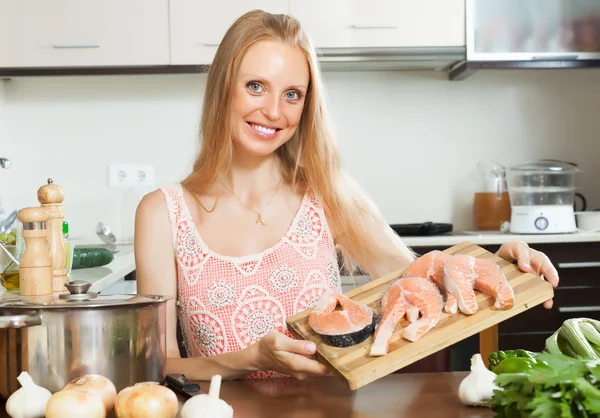 Mujer sonriente con salmón crudo — Foto de Stock