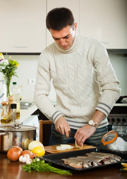 Chico cocinar pescado crudo con cebolla en sartén para asar — Foto de Stock