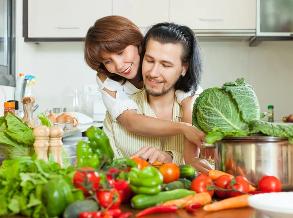 Casal atraente preparando salada vegetal — Fotografia de Stock