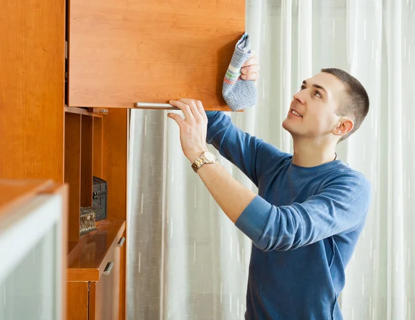 Uomo pulizia mobili in legno — Foto Stock