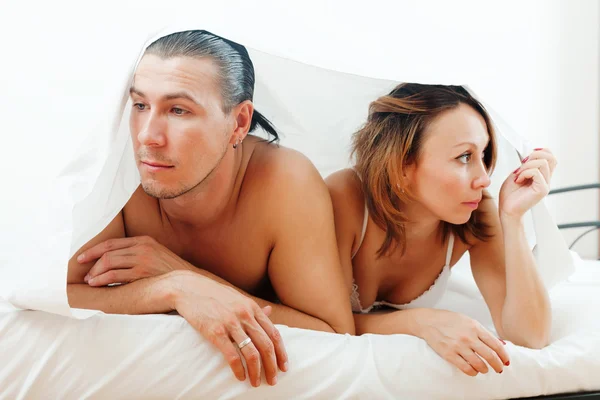 Unhappy couple under sheet — Stock Photo, Image