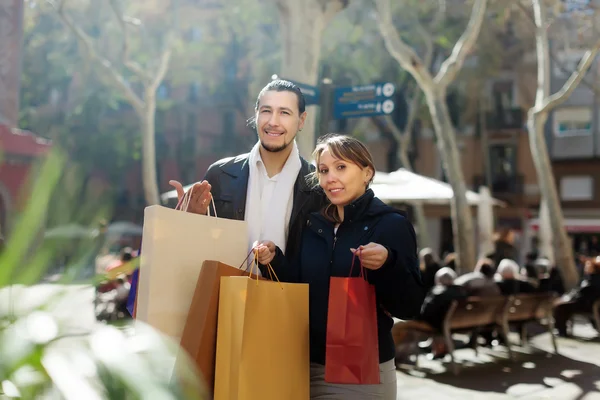 Coppia sorridente con acquisti in strada — Foto Stock