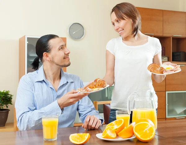 Smiling woman serves breakfast her  man — Stock Photo, Image