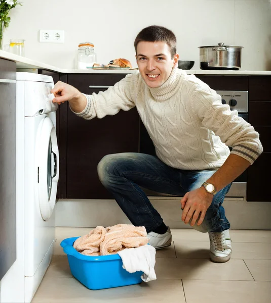 Guy putting clothes into washing machine — Stock Photo, Image