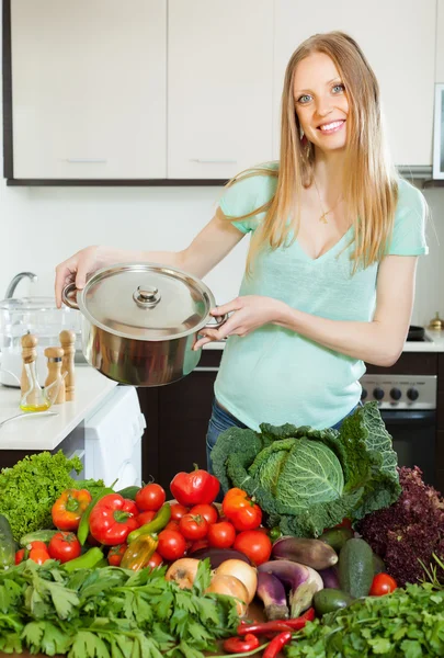 Mujer rubia feliz con sartén y verduras —  Fotos de Stock