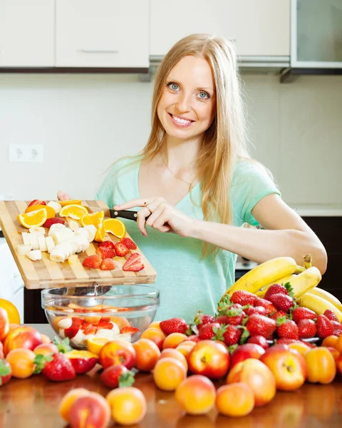 Vrouw koken fruitsalade — Stockfoto