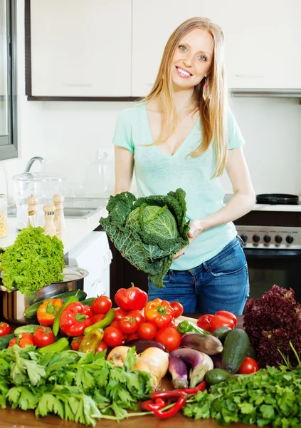 Vacker kvinna med grönsaker i hemmet köket — Stockfoto