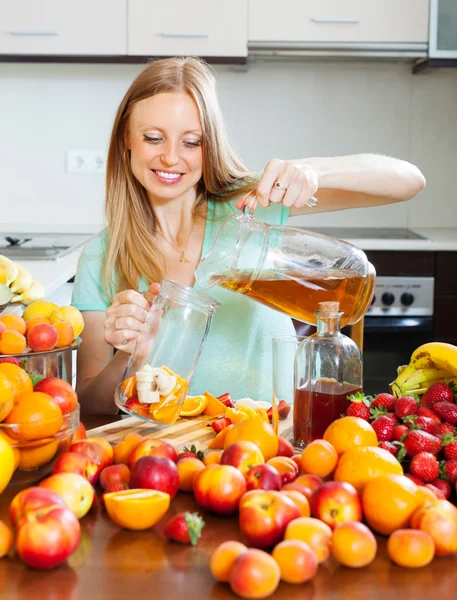 Menina loira positiva derramando bebidas frescas — Fotografia de Stock