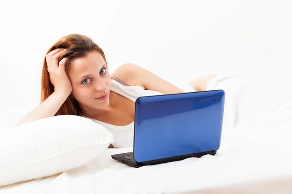 Woman with laptop  in her bed at home Royalty Free Stock Images