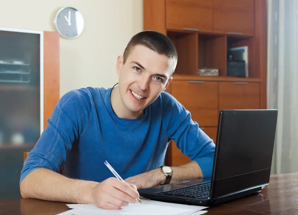 Tipo mirando documentos financieros en la mesa — Foto de Stock