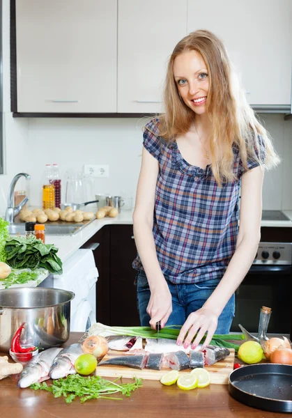 Позитивная домохозяйка готовит соленую рыбу — стоковое фото