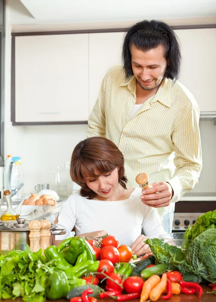 Vrouw en man zout aan de pot en in huis keuken — Stockfoto