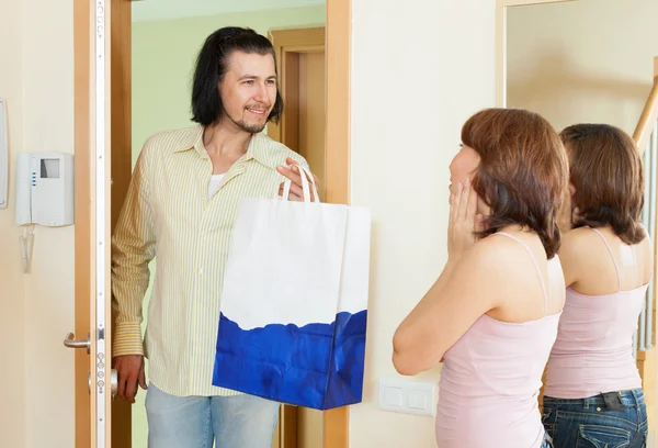 El hombre ha llegado a la mujer con el regalo en casa — Foto de Stock