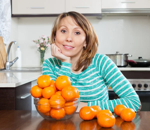 Donna con mucchio di mandarini — Foto Stock