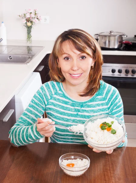 Mulher sorridente comendo arroz cozido — Fotografia de Stock