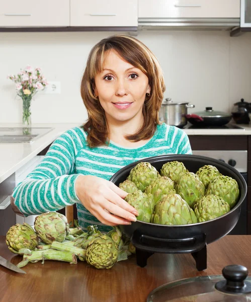 Lachende vrouw met artisjokken — Stockfoto