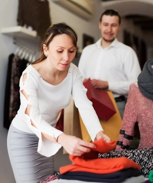 Pareja sonriente eligiendo ropa en boutique — Foto de Stock