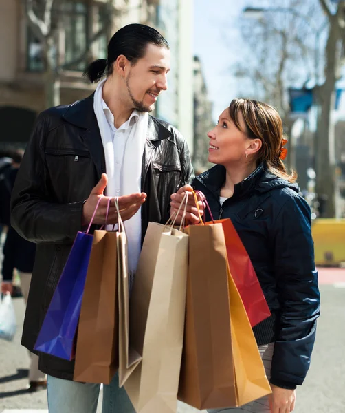 Man and girl with shopping bags at street — Stock Photo, Image