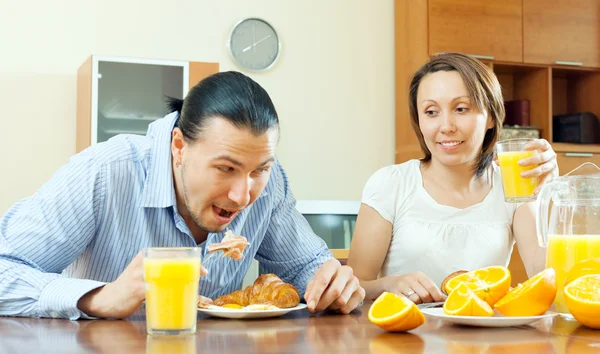 Casal feliz tomando café da manhã com croissants — Fotografia de Stock