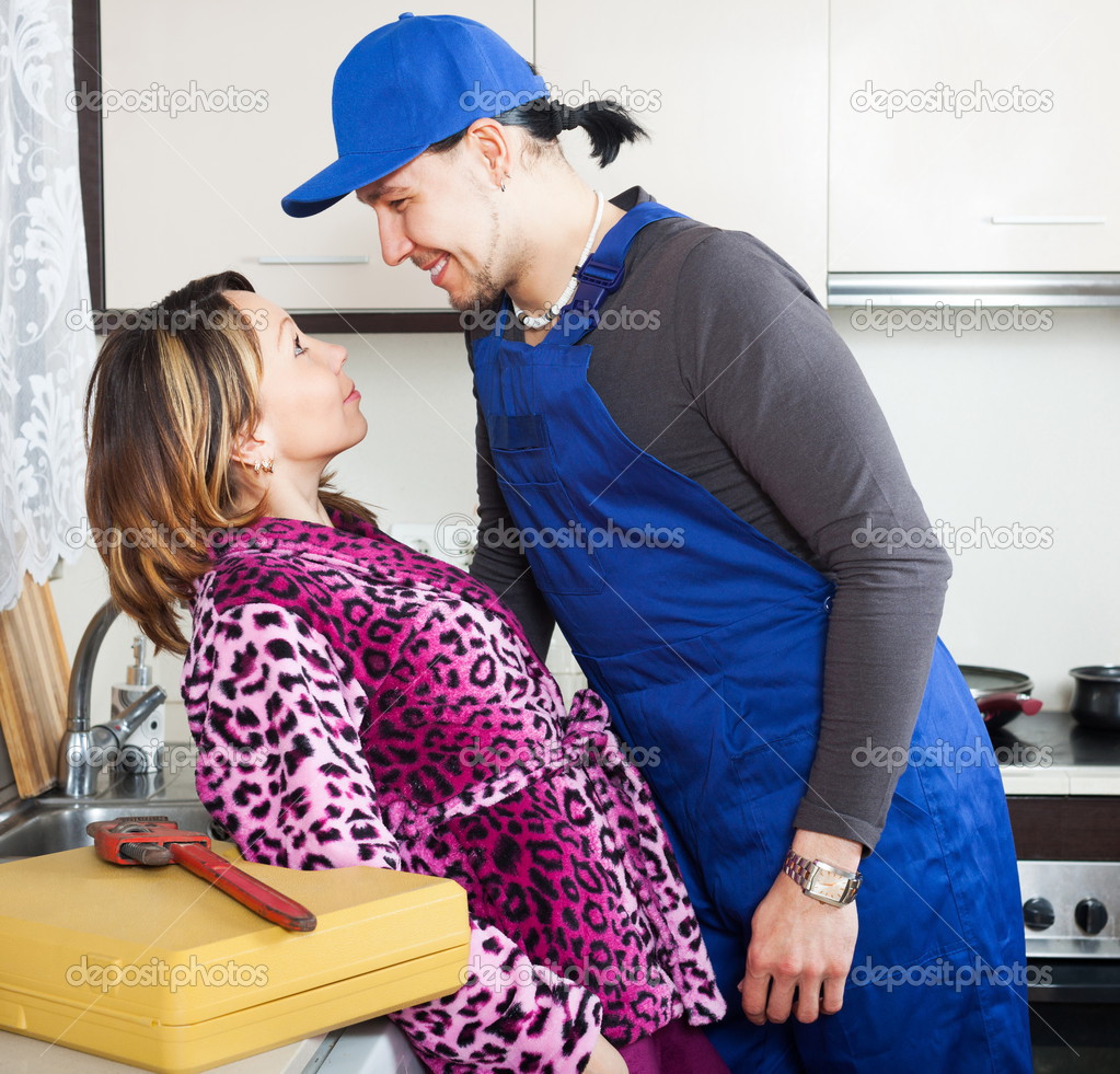 Playful woman flirting with repairman Stock Photo by ©Jim_Filim 47145327