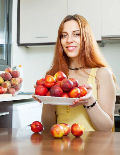 Jeune femme au foyer tenant des nectarines — Photo