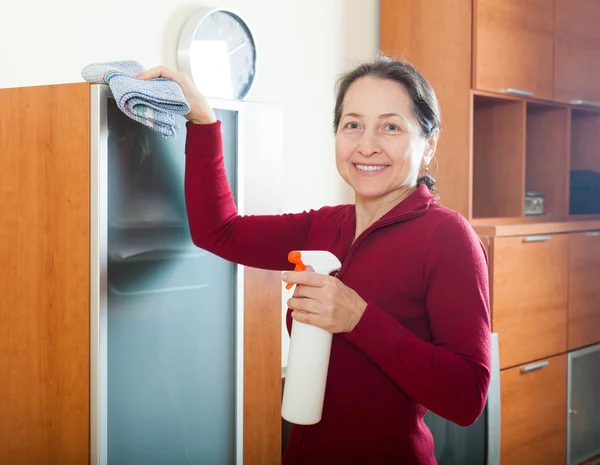 Sorrindo mulher madura limpeza móveis — Fotografia de Stock